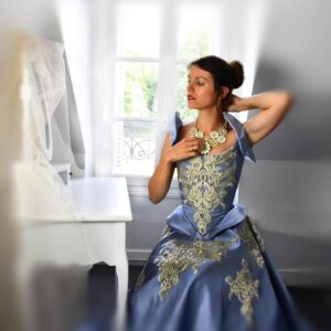 Femme portant une robe ancienne bleue sur mesure, confectionnée par l’atelier Efti Cianko.X